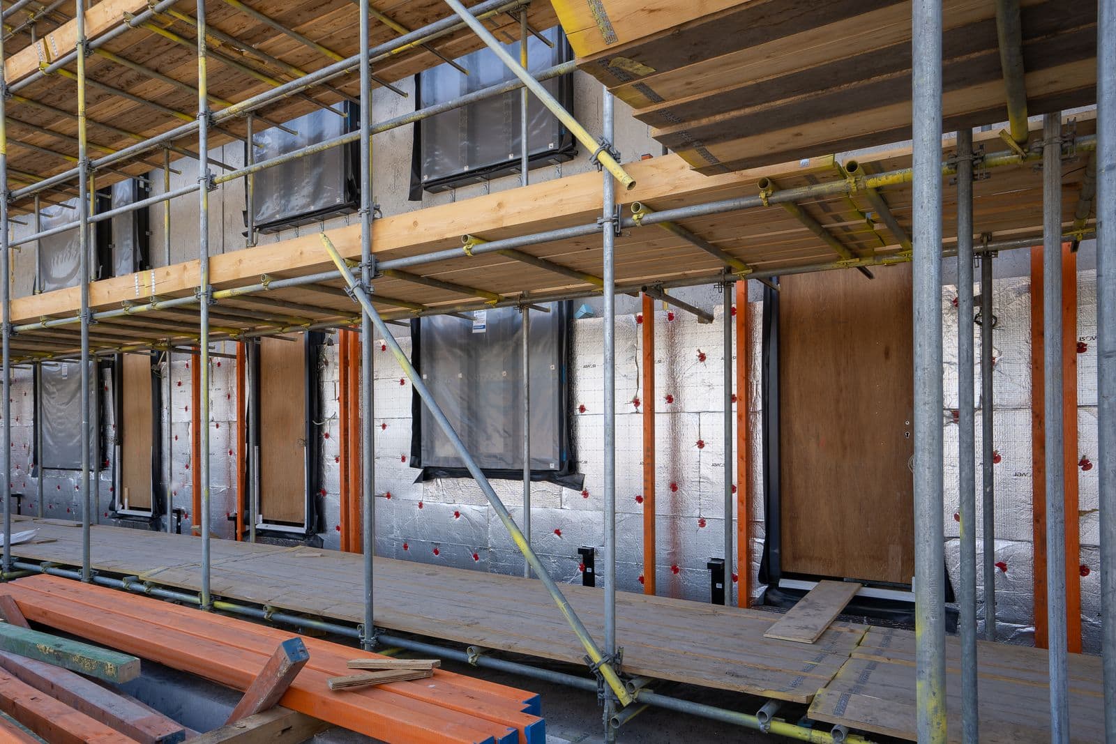 Scaffolding in front of a house wall with insulation boards exposed