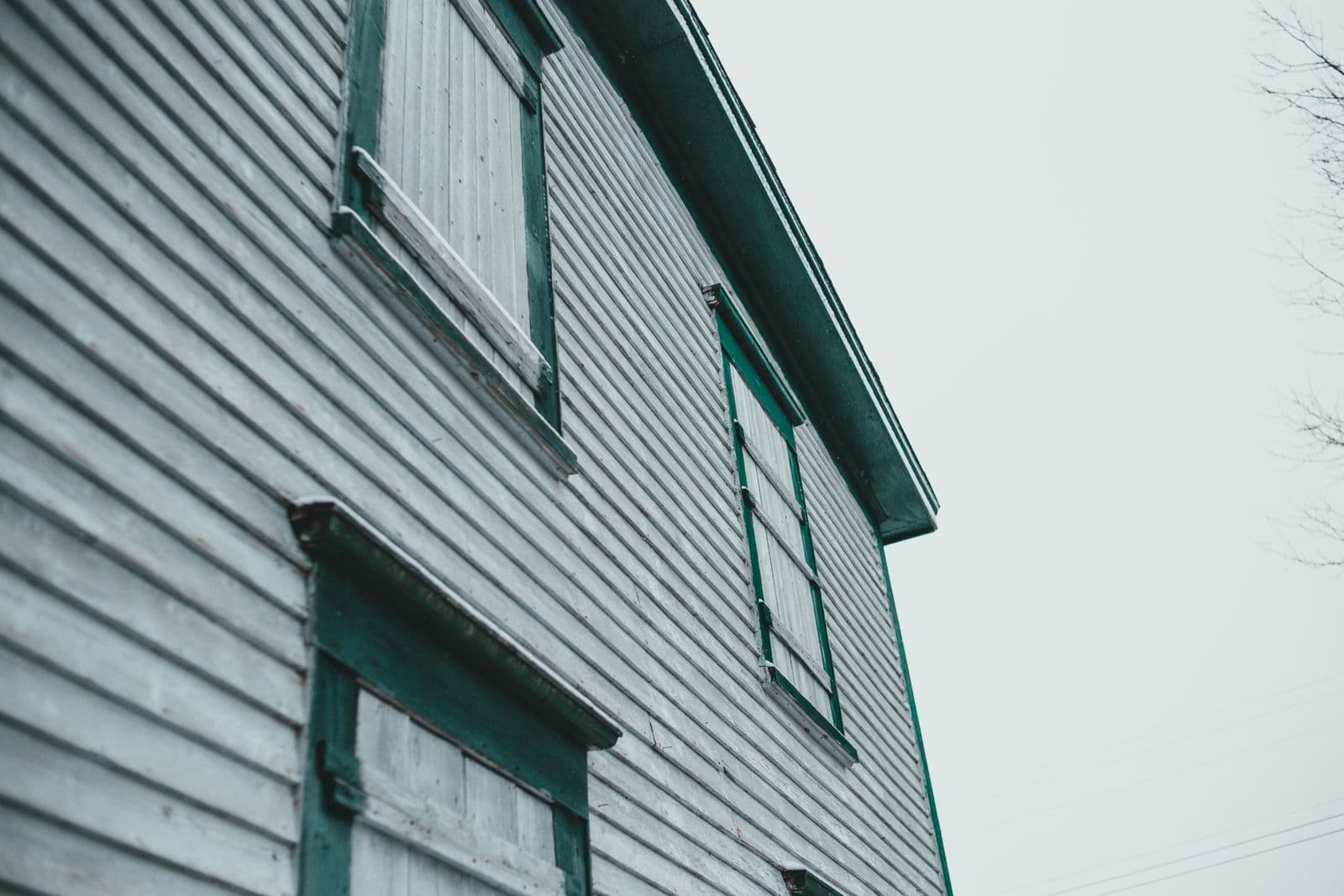 Painted wooden siding and shutters seen from below