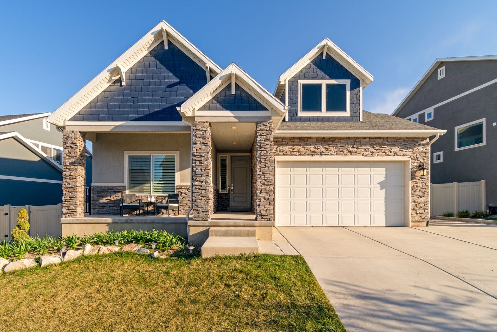 House with blue and tan siding over a stone front